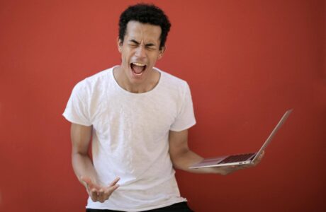 young ethnic male with laptop screaming