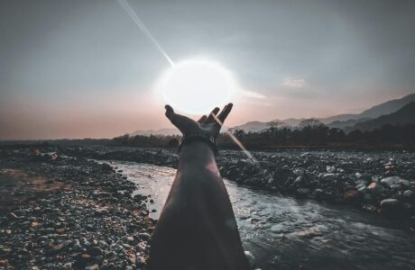 person hand reaching for the sun